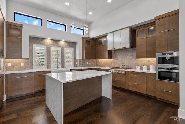 kitchen with a healthy amount of sunlight, appliances with stainless steel finishes, dark wood finished floors, and light countertops