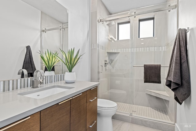 bathroom with a stall shower, vanity, and toilet