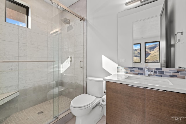 bathroom featuring plenty of natural light, backsplash, toilet, and vanity