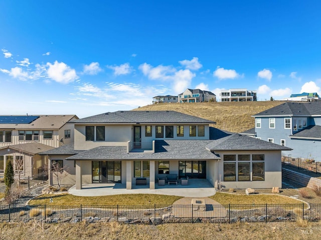 back of house featuring a residential view, a patio area, a fenced backyard, and stucco siding