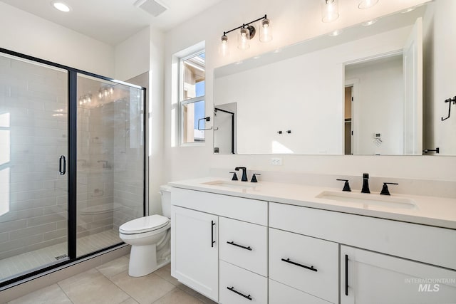 bathroom with double vanity, a sink, visible vents, and tile patterned floors