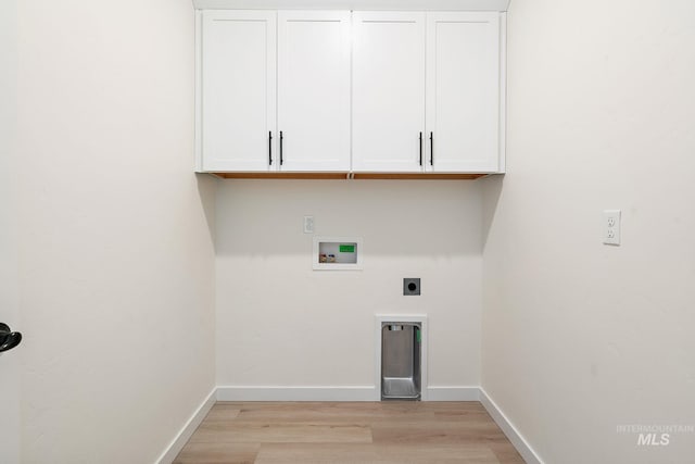 washroom featuring hookup for a washing machine, cabinet space, light wood-style flooring, hookup for an electric dryer, and baseboards