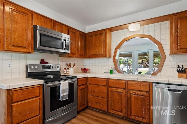 3752 Lancer Way, Boise, ID 83713 - kitchen with stainless steel appliances, tasteful backsplash, brown cabinets, wood finished floors, and a sink