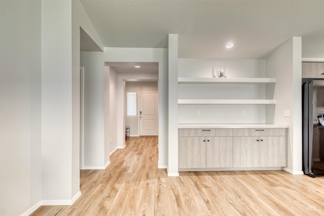 4913 Endicott Dr, Caldwell, ID 83605 - kitchen featuring light wood-type flooring, black fridge, open shelves, light countertops, and light brown cabinets