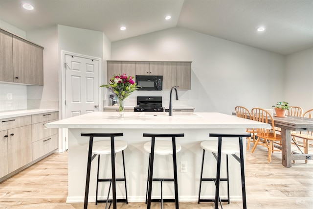 4913 Endicott Dr, Caldwell, ID 83605 - kitchen featuring modern cabinets, black microwave, a kitchen bar, range, and recessed lighting