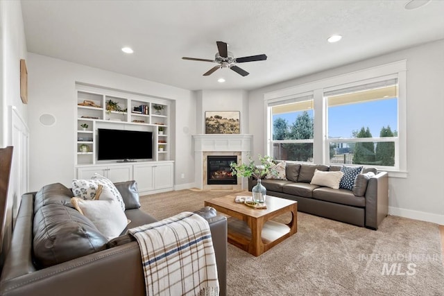 living room with ceiling fan, built in features, and light carpet