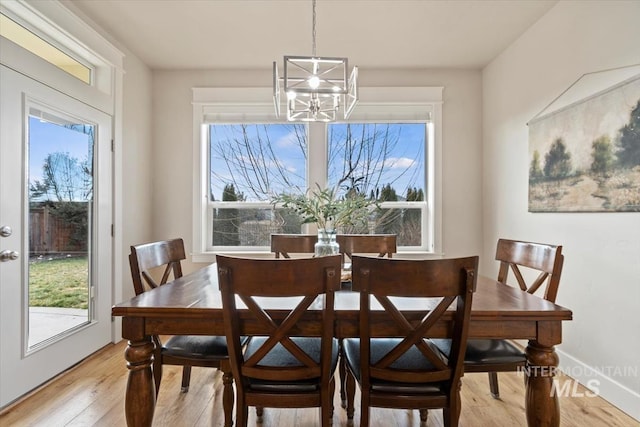 dining space featuring an inviting chandelier and light hardwood / wood-style floors