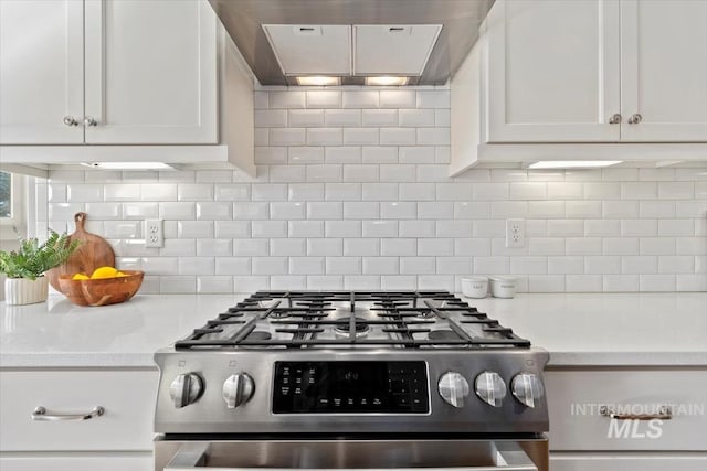 kitchen with gas range, white cabinetry, decorative backsplash, and exhaust hood