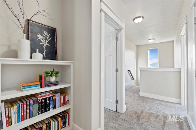 hall featuring light colored carpet