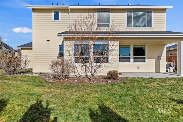 back of house with a yard and a patio area