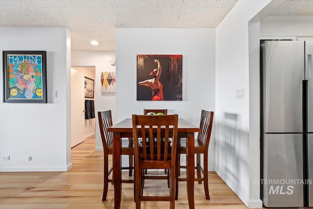 dining room featuring baseboards and light wood-style floors