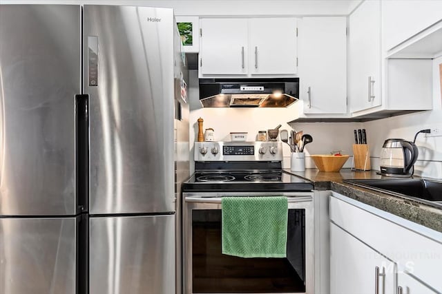 kitchen with under cabinet range hood, a sink, white cabinets, appliances with stainless steel finishes, and dark countertops