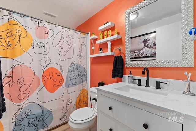 bathroom featuring a shower with shower curtain, visible vents, vanity, and toilet