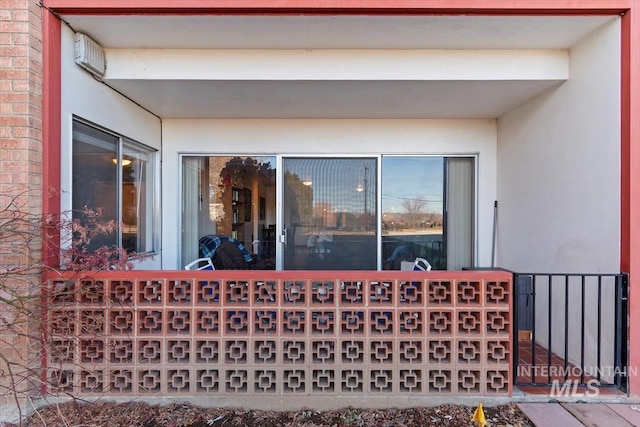 entrance to property with brick siding and stucco siding