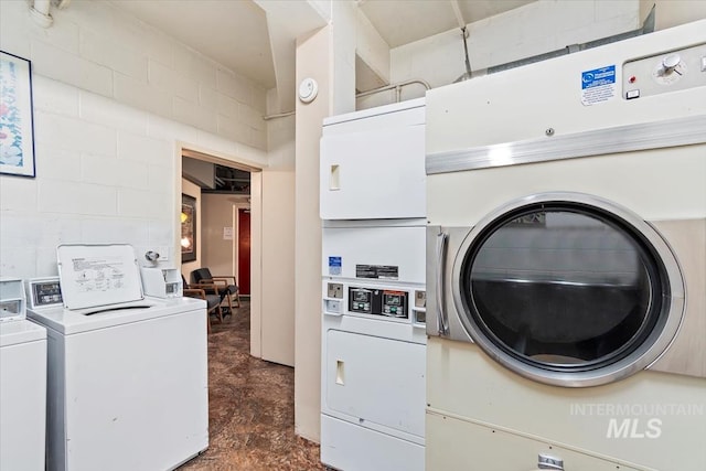 shared laundry area with washing machine and clothes dryer and concrete block wall