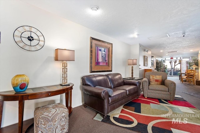 carpeted living room with a textured ceiling