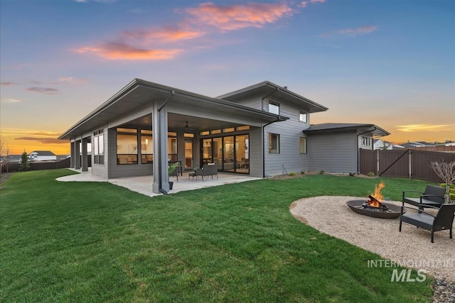 9891 W Napier Ct, Star, ID 83669 - back of house at dusk featuring an outdoor fire pit, a patio area, and ceiling fan