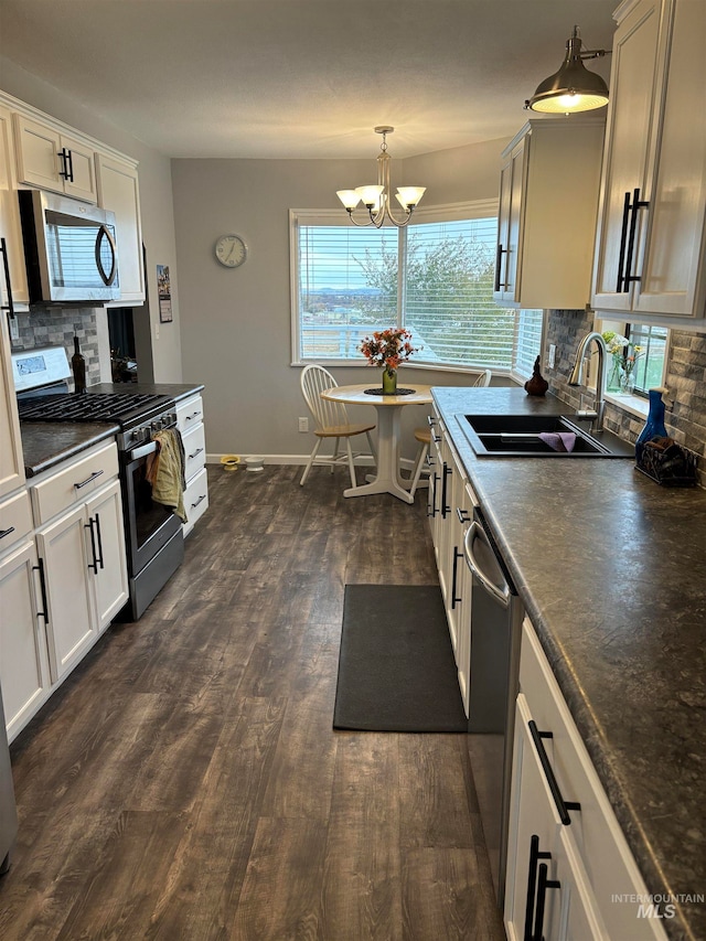 kitchen with backsplash, dark hardwood / wood-style flooring, stainless steel appliances, sink, and decorative light fixtures