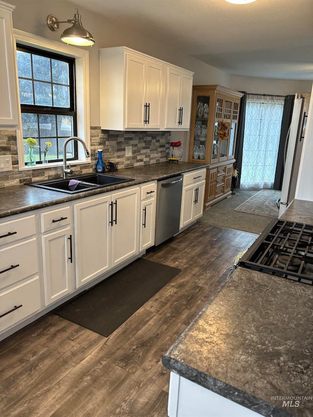 kitchen featuring dishwasher, dark hardwood / wood-style floors, white cabinetry, and sink