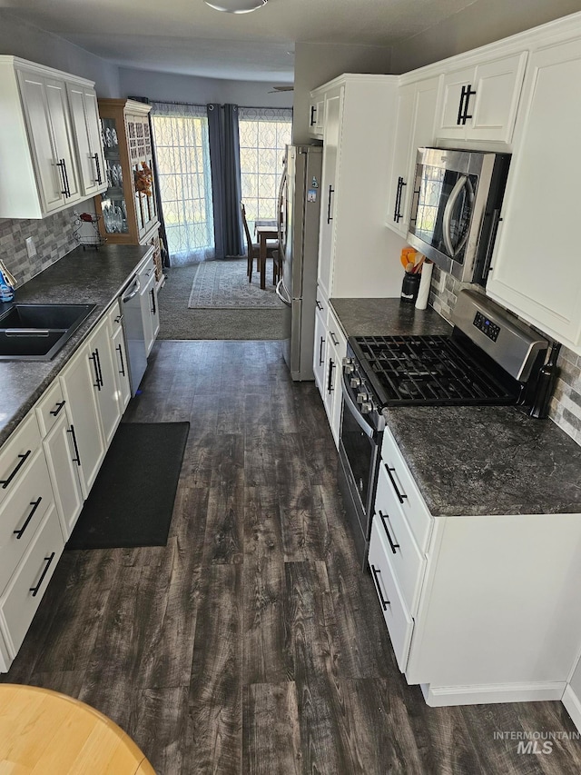 kitchen featuring tasteful backsplash, sink, white cabinets, and appliances with stainless steel finishes