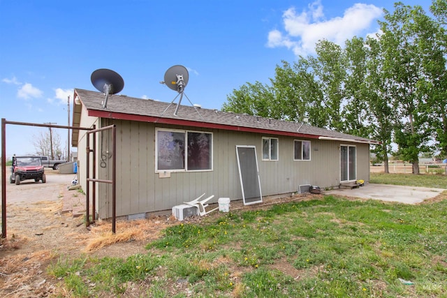 27410 Peckham Rd, Wilder, ID 83676 - back of property featuring a shingled roof, a patio area, fence, and a lawn