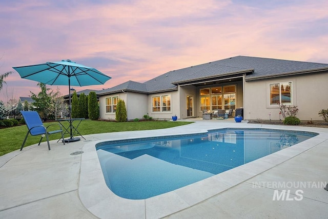 3061 S Fox Run Ave, Eagle, ID 83616 - pool at dusk featuring an outdoor pool, a patio area, and a lawn