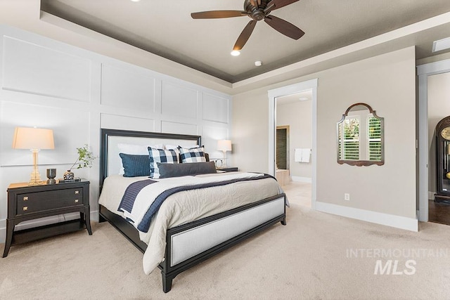 3061 S Fox Run Ave, Eagle, ID 83616 - bedroom featuring light colored carpet, a tray ceiling, baseboards, ensuite bathroom, and a ceiling fan