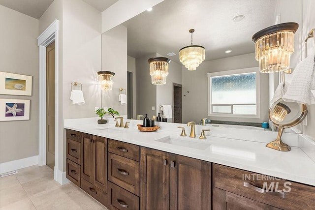 3061 S Fox Run Ave, Eagle, ID 83616 - bathroom featuring a chandelier, tile patterned floors, double vanity, and baseboards