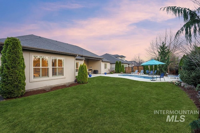 3061 S Fox Run Ave, Eagle, ID 83616 - back of property at dusk featuring a patio area and stucco siding