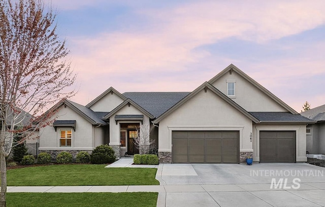 3061 S Fox Run Ave, Eagle, ID 83616 - view of front of home with stucco siding, an attached garage, stone siding, concrete driveway, and a front yard