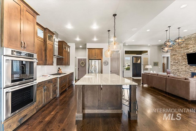 3061 S Fox Run Ave, Eagle, ID 83616 - kitchen with wall chimney exhaust hood, stainless steel appliances, open floor plan, dark wood-type flooring, and glass insert cabinets