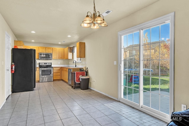 kitchen featuring sink, hanging light fixtures, appliances with stainless steel finishes, a notable chandelier, and light tile patterned flooring