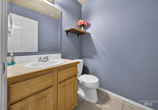 bathroom with tile patterned flooring, vanity, and toilet