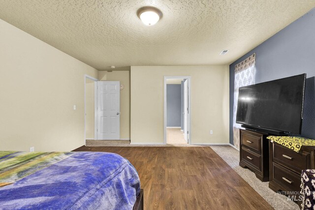 bedroom with a textured ceiling and hardwood / wood-style flooring