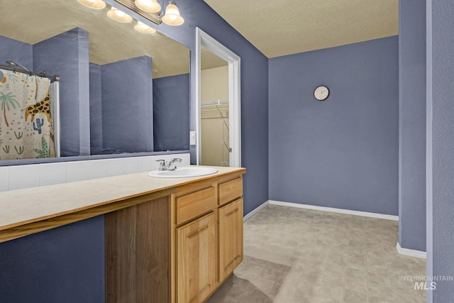 bathroom with vanity, a textured ceiling, and walk in shower