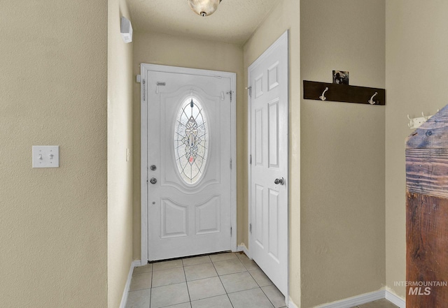 foyer featuring light tile patterned floors and a textured ceiling