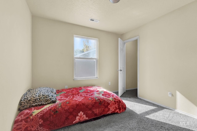 bedroom with carpet and a textured ceiling