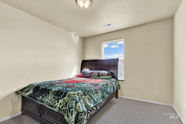 bedroom featuring light carpet and a textured ceiling