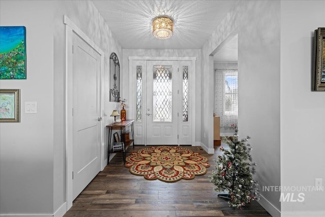 entrance foyer with baseboards and wood finished floors