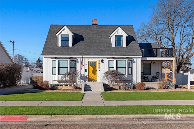 cape cod house featuring a front yard