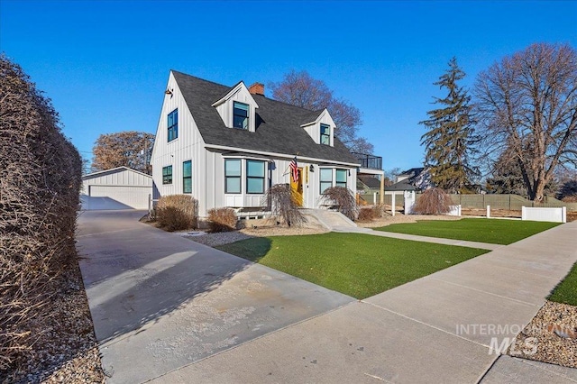 view of front facade with a garage, an outdoor structure, and a front lawn