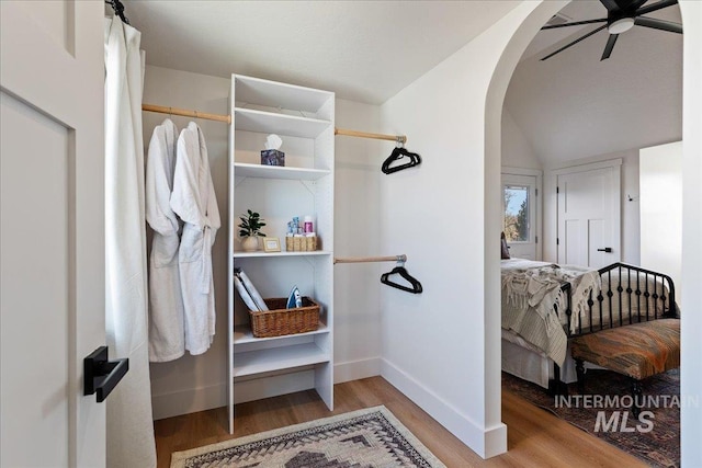 spacious closet with ceiling fan, lofted ceiling, and hardwood / wood-style floors