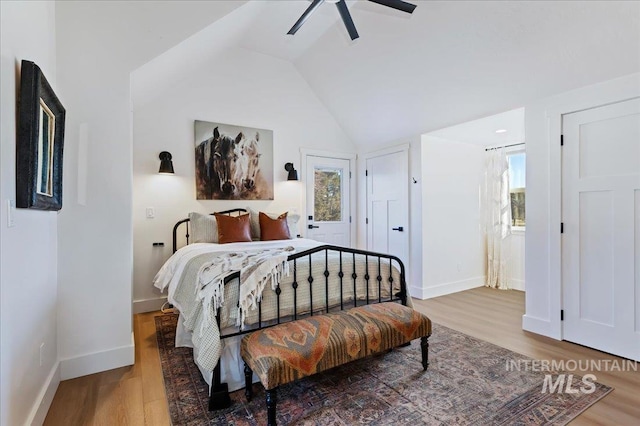 bedroom featuring hardwood / wood-style flooring, vaulted ceiling, and ceiling fan