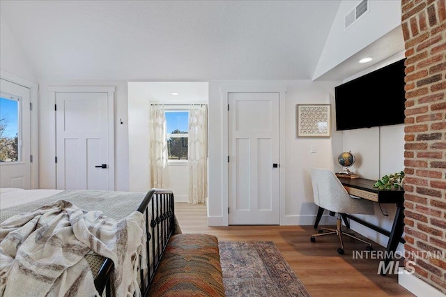 bedroom with lofted ceiling and light hardwood / wood-style flooring