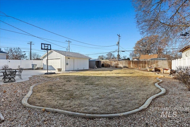 view of yard featuring a storage unit, a patio area, and a garage