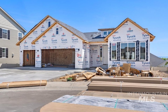 property in mid-construction with concrete driveway