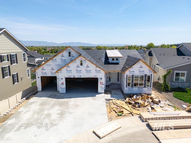 unfinished property with concrete driveway, an attached garage, a mountain view, and a residential view