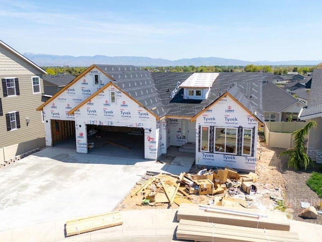property in mid-construction featuring concrete driveway, a mountain view, and a garage