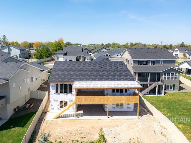 back of property featuring a fenced backyard, a lawn, and a residential view