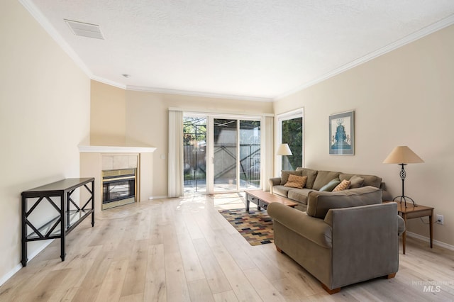 2072 N 28th St, Boise, ID 83702 - living room featuring light wood-style flooring, ornamental molding, baseboards, and a tiled fireplace